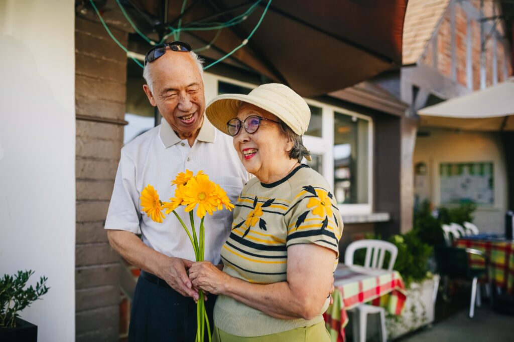 Elderly couple holding flowers