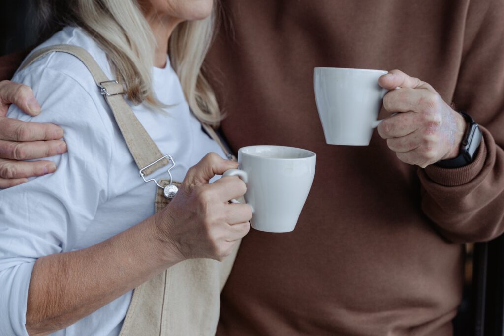 older couple holding coffee cups